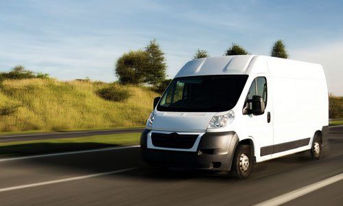 Courier van travelling on a country road