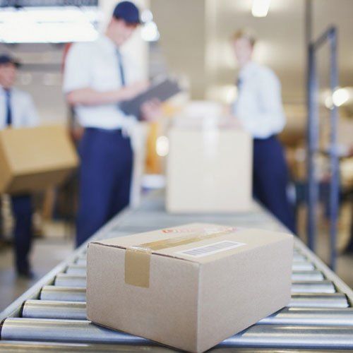 Parcel on a conveyor in a busy warehouse